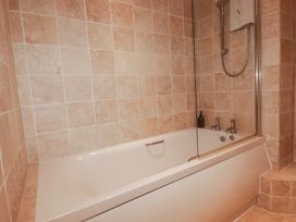 A bathroom with a bathtub and shower at Kingfisher Cottage in Edmonton, near Wadebridge