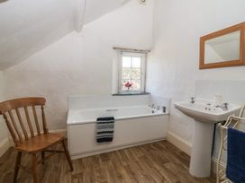 A bathroom with a bath tub and sink at Tregonhawke Farmhouse in Millbrook