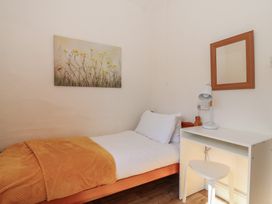 A bedroom with a bed, desk, and mirror at Tregonhawke Farmhouse in Millbrook