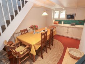 A kitchen with a dining table and chairs at Mural Cottage in Mousehole