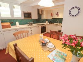 A kitchen with table and chairs at Mural Cottage in Mousehole