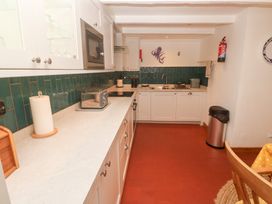 A kitchen with a countertop and appliances at Mural Cottage Mousehole
