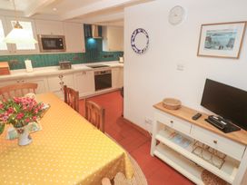 A kitchen with a table and chairs at Mural Cottage in Mousehole