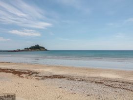 A view of a beach and ocean with an island in the distance at 2 The Cottages Ludgvan