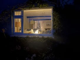 A living room with a Christmas tree and a lamp at Clamoak Cottage in Clamoak near Bere Alston