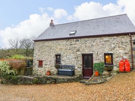 A stone cottage with a bench and plants at Old Farmhouse Cottage