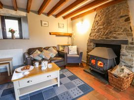 A living room with a fireplace and seating at Old Farmhouse Cottage 