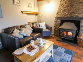 A living room with a fireplace and a coffee table at Old Farmhouse Cottage