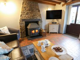 A living room with a fireplace and tea set at Old Farmhouse Cottage