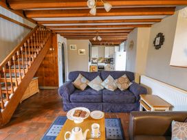 A living room with a sofa table and stairs at Old Farmhouse Cottage