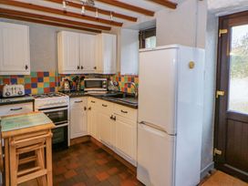 A kitchen with cabinets, appliances, and a window at Old Farmhouse Cottage
