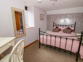 A bedroom with a bed and mirror at Old Farmhouse Cottage