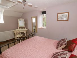 A bedroom with a bed and a mirror at Old Farmhouse Cottage