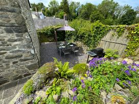 A garden with a dining set and grill at Old Farmhouse Cottage