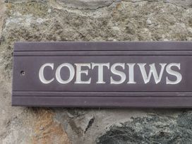 A sign reading Coetsiws mounted on a stone wall at Coetsiws in Clynnog Fawr