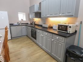 A kitchen with cupboards and appliances at Coetsiws in Clynnog Fawr