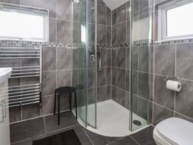 A bathroom with a shower and towel radiator at Coetsiws in Clynnog Fawr