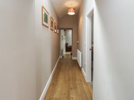A hallway with floor and light fixture at Coetsiws in Clynnog Fawr