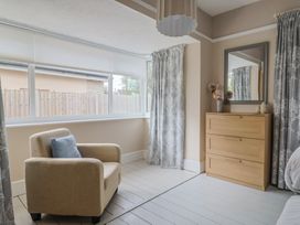 A bedroom with an armchair and dresser at Sunny Croft in Broadmayne near Dorchester