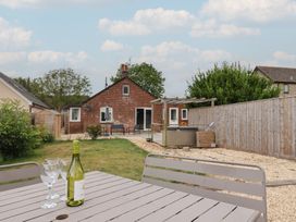 A garden with a table, chairs and hot tub at Sunny Croft in Broadmayne near Dorchester