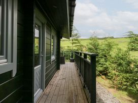 An outdoor area with a deck and trees at Oak Lodge in Pennington near Ulverston