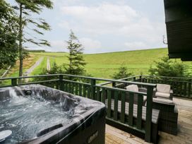 An outdoor area with a hot tub and seating at Oak Lodge in Pennington near Ulverston