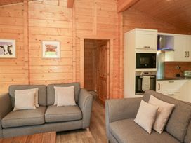 A living room with sofas and kitchen units at Oak Lodge Pennington near Ulverston