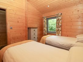 A bedroom with two beds and a dresser at Oak Lodge Pennington near Ulverston