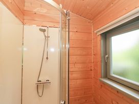 A shower enclosure with wooden paneling at Oak Lodge in Pennington near Ulverston