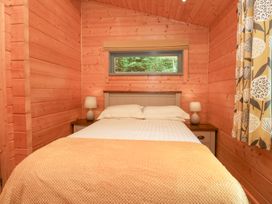 A bedroom with a bed and window at Oak Lodge Pennington near Ulverston