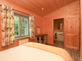 A bedroom with a bed and an adjoining bathroom at Oak Lodge in Pennington near Ulverston