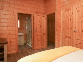 A bedroom with doors leading to a bathroom at Oak Lodge in Pennington near Ulverston