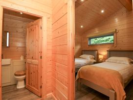 A bedroom with two beds and a bathroom at Oak Lodge Pennington near Ulverston