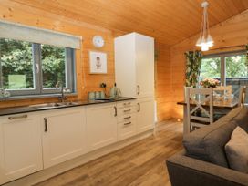 A kitchen with a sink and dining table at Oak Lodge Pennington near Ulverston