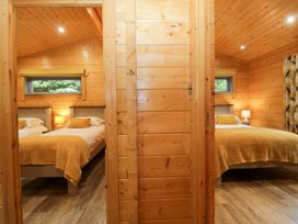 A bedroom with two beds and a window at Oak Lodge Pennington near Ulverston