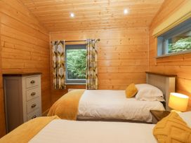 A bedroom with two beds and a window at Oak Lodge Pennington near Ulverston