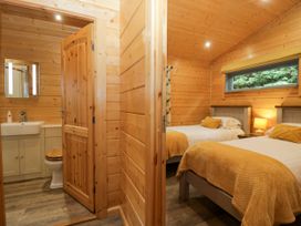 A bedroom with two beds and a bathroom at Oak Lodge Pennington near Ulverston
