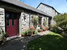 An outdoor entrance with flower pots and a pathway at Brunnion Cottage in St Ives