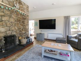 A living room with a television and fireplace at Tyn Morfa in Llangwnnadl near Aberdaron