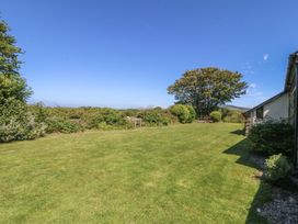 A garden with grass and a tree at Tyn Morfa in Llangwnnadl near Aberdaron