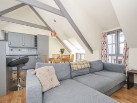 A living room with a sofa and dining area at Beach Retreat in Looe