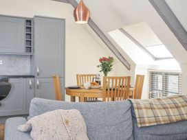 A kitchen with a dining table and flowers at Beach Retreat in Looe
