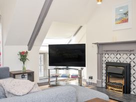 A living room with a television and sofa at Beach Retreat Looe