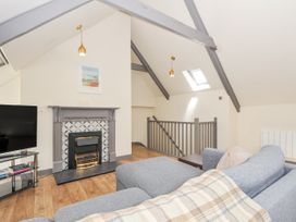 A living room with a fireplace and television at Beach Retreat in Looe