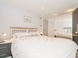 A bedroom with a bed and mirror at Beach Retreat in Looe