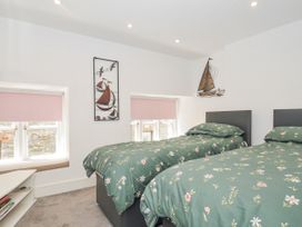 A bedroom with two beds and decor at Beach Retreat in Looe