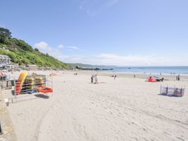 A beach with kayaks and umbrellas at Beach Retreat in Looe