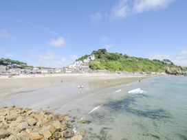 A beach with water and people at Beach Retreat in Looe