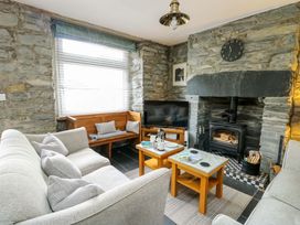 A living room with a sofa and fireplace at Garreg Ddu in Blaenau Ffestiniog