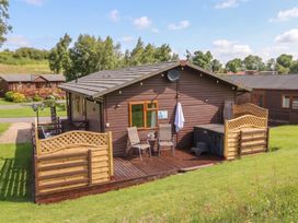 A lodge with a deck and hot tub at 16 Badgers Retreat in Richmond